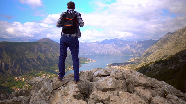 男旅人高举双手站在山顶上视频素材