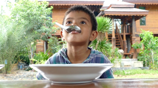 亚洲小男孩在家里吃米饭视频素材