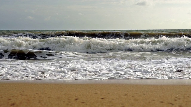 日落海滩与海浪撞击海岸地平线上的水视频素材