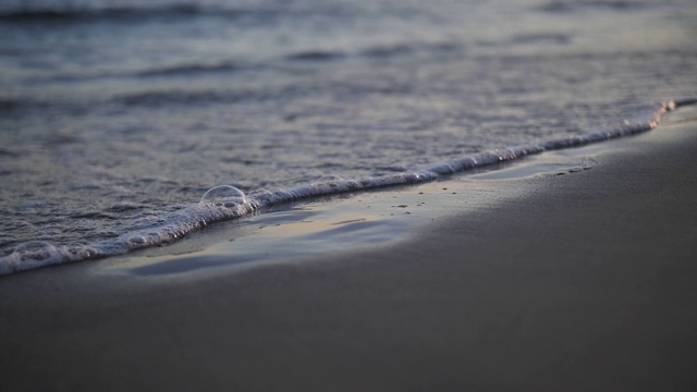 脚在海边的沙滩上留下痕迹，海水会把这些痕迹冲掉视频素材