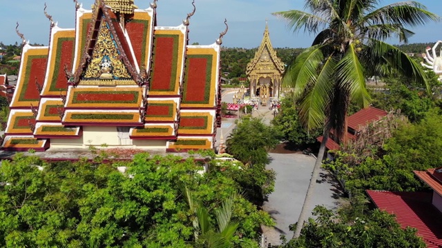 湖边的佛寺。在阳光明媚的日子里，苏梅湖附近的屋顶和寺庙的雕像被无人机俯视。白莲寺的微笑佛和观音视频素材