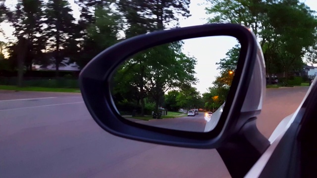 Driving Residential Road View of Side Mirror。沿着美丽的郊区街道的侧视镜POV。视频素材