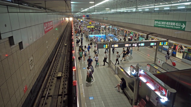 人群与火车在地下铁路隧道。台湾台北市交通背景下的地铁。视频素材