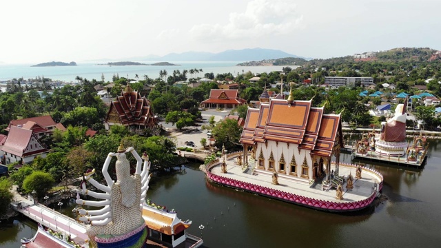 湖边的佛寺。在阳光明媚的日子里，苏梅湖附近的屋顶和寺庙的雕像被无人机俯视。白莲寺的微笑佛和观音视频素材