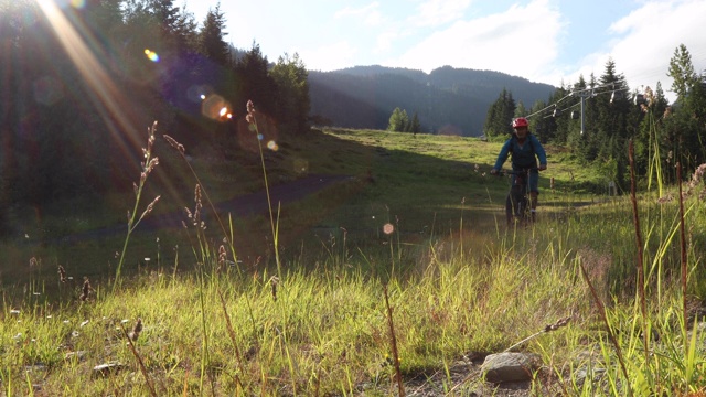 山地摩托车手沿着山路穿过山林视频素材