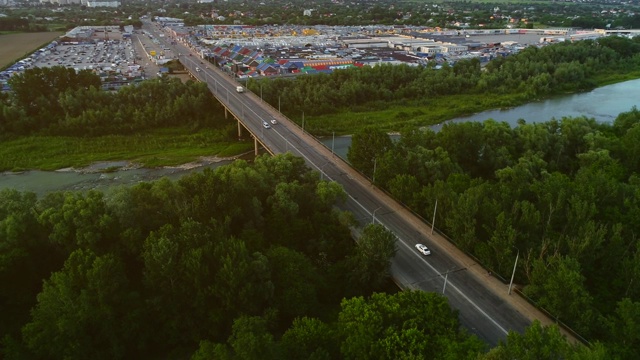 航拍高速公路和汽车，这是快速移动的桥梁附近的商业企业。4 k。视频素材