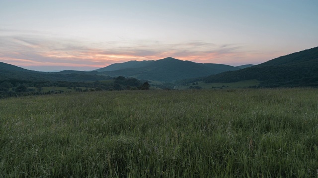 波兰Bieszczady山脉草地上的彩色日落。视频素材