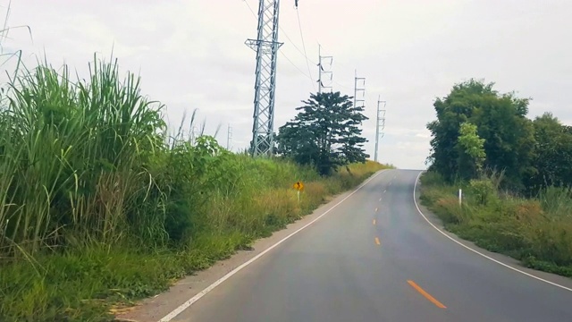 行驶在乡间乡间景色的小路上，旁边是一座山视频素材