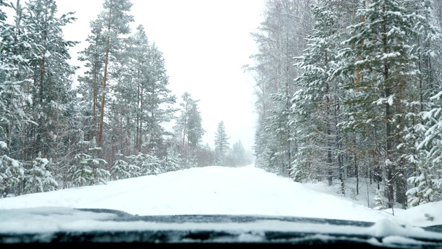 雪天里，汽车停在积雪的森林路上。视频素材