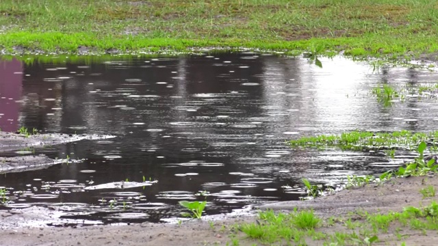 水珠滴落在地上的水坑里。黑暗，悲伤，情绪化和戏剧性的背景。视频素材