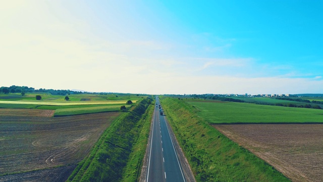 鸟瞰图，它缓慢地降低焦点，在一个电影般的道路上的巨大卡车，位于惊人的风景。4 k。视频素材