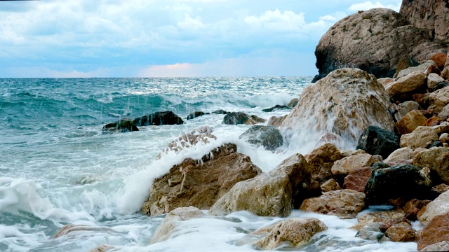 海浪拍打着多岩石的海岸。视频素材