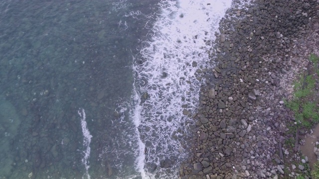 在被海浪淹没的海滩上，飞过石头和卵石视频素材