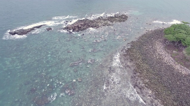 在被海浪淹没的海滩上，飞过石头和卵石视频素材