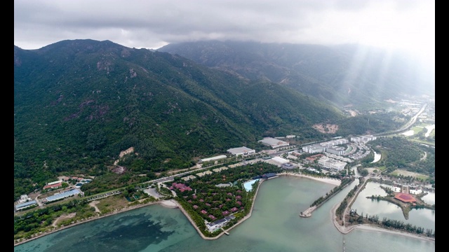 空中拍摄:在越南芽川，海岸度假村旁边美丽的，树木覆盖的崎岖山脉。视频下载