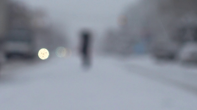 暴风雪来了。在被雪覆盖的道路上行驶的汽车。的焦点。在冬天拍摄。视频素材