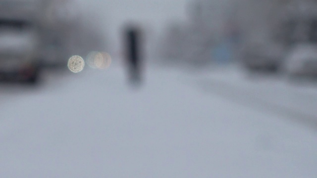 暴风雪来了。在被雪覆盖的道路上行驶的汽车。的焦点。在冬天拍摄。视频素材