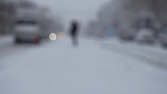 暴风雪来了。在被雪覆盖的道路上行驶的汽车。的焦点。在冬天拍摄。视频素材