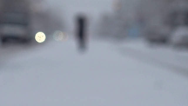 暴风雪来了。在被雪覆盖的道路上行驶的汽车。的焦点。在冬天拍摄。视频素材