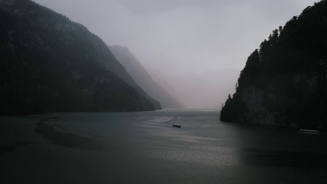 航拍的船航行在巴伐利亚阿尔卑斯湖，德国在大雨期间视频素材