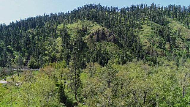 风景鸟瞰图之间的山响尾蛇荒野地区，米苏拉县，蒙大拿州，在阳光明媚的春天。无人机视频与向前摄像机运动。视频素材