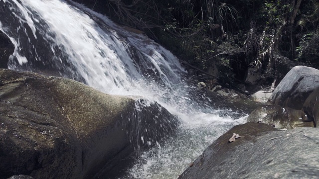 山河中的水流倾泻在巨石上。山上瀑布的水迅速地流入岩石河中。山间湍急的小溪视频素材