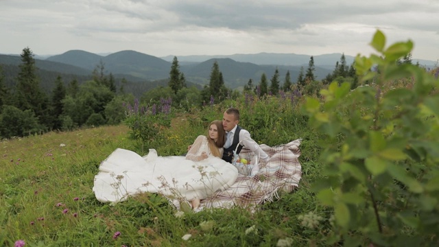 新郎和新娘在山上野餐。婚礼的夫妇。家庭视频素材