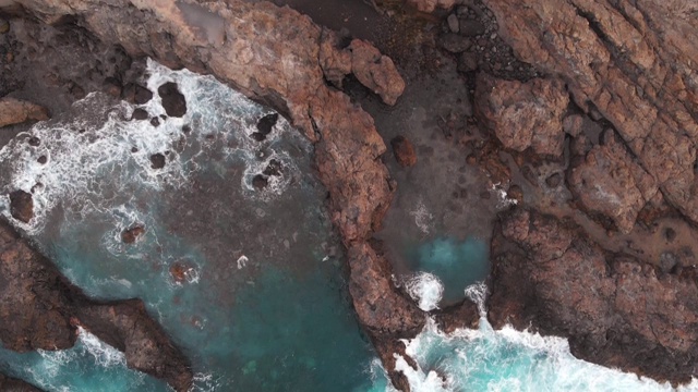 特内里费岛的天然水池是一个神秘的地方。鸟瞰图。冰冻熔岩的悬崖和蓝绿色的海洋视频素材