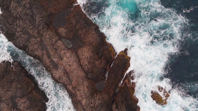 鸟瞰图-大波浪在岩石海岸的大西洋。大量的海水泡沫。西班牙特内里费岛的火山岩视频素材