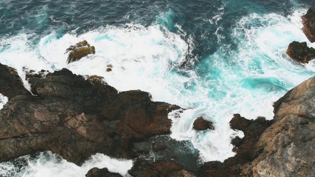 鸟瞰图海浪和美丽的特内里费岛岩石海岸。危险的海浪撞击着从到达海洋并冻结的熔岩中冒出的大岩石视频素材