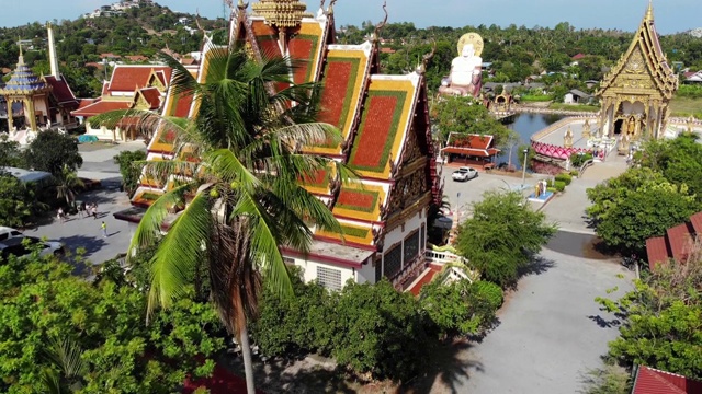 湖边的佛寺。在阳光明媚的日子里，苏梅湖附近的屋顶和寺庙的雕像被无人机俯视。白莲寺的微笑佛和观音视频素材