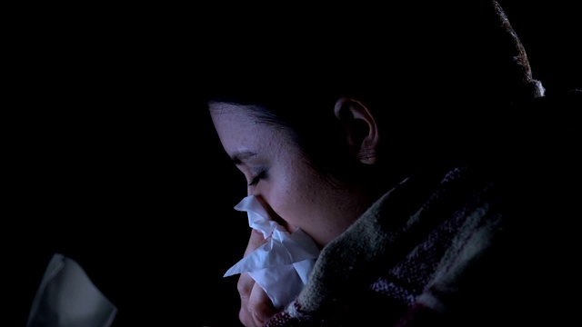 生病的女孩包裹在毯子打喷嚏遭受季节性流感，特写视频素材