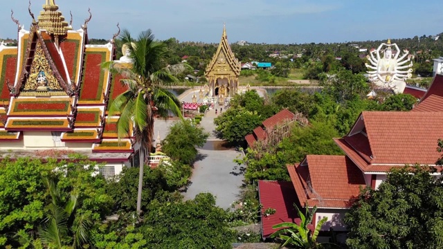 湖边的佛寺。在阳光明媚的日子里，苏梅湖附近的屋顶和寺庙的雕像被无人机俯视。白莲寺的微笑佛和观音视频素材