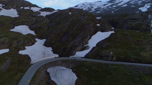 航拍:挪威达尔斯尼巴山高原冬季在雪地里的公路上行驶的房车视频素材