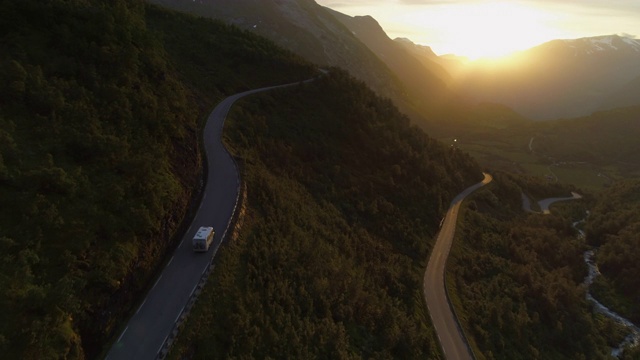 航拍:日落时分，挪威盖兰格峡湾，一架无人机飞向行驶在山间蜿蜒公路上的房车视频素材