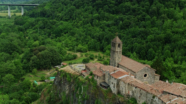 无人机飞过罗卡城堡(Castellfollit de la Roca)悬崖顶上的石屋视频素材