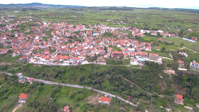 希腊阿托斯哈尔基迪基(Athitos Halkidiki)山上沿海旅游村庄的鸟瞰图，由无人机来回移动视频素材