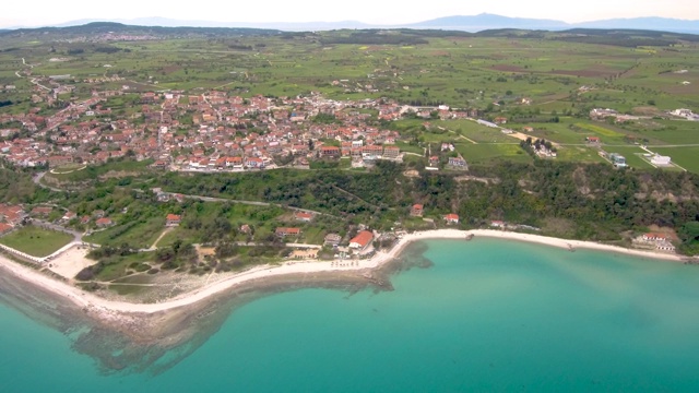 希腊阿托斯哈尔基迪基(Athitos Halkidiki)山上沿海旅游村庄的鸟瞰图，由无人机来回移动视频素材