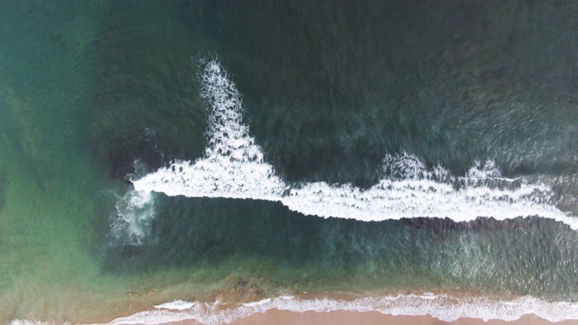 礁石在海滩上制造波浪视频素材