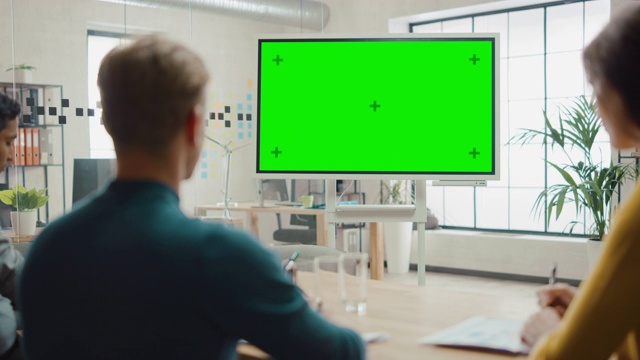 企业家团队开会观看绿屏互动白板。年轻人在创意办公室工作视频素材