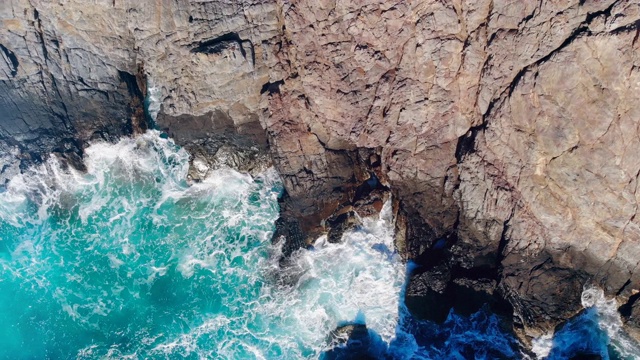 碧绿的海水拍打着海岸上的岩石。视频素材