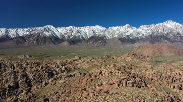 空中背:岩石山，绿色的滚动平原，和高雪顶山脉-阿拉巴马山，加利福尼亚视频素材