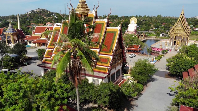 湖边的佛寺。在阳光明媚的日子里，苏梅湖附近的屋顶和寺庙的雕像被无人机俯视。白莲寺的微笑佛和观音视频素材