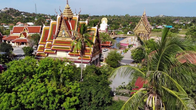 湖边的佛寺。在阳光明媚的日子里，苏梅湖附近的屋顶和寺庙的雕像被无人机俯视。白莲寺的微笑佛和观音视频素材