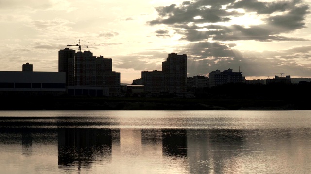 河岸上的城市剪影。城市上空的云朵。城市和日落。视频素材