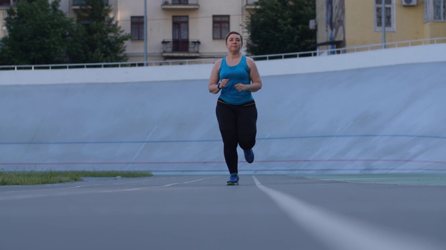 在体育场跑道上训练超重女性跑步者视频素材