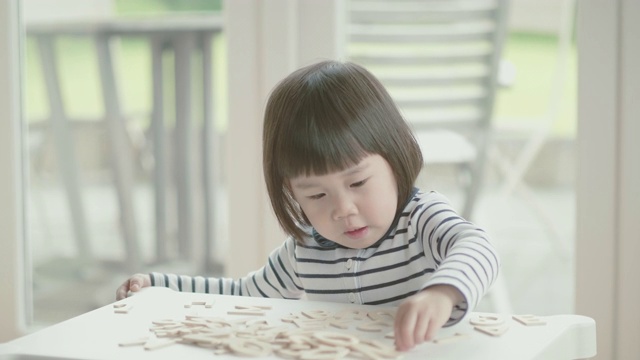 蹒跚学步的小女孩在家学习字母视频素材