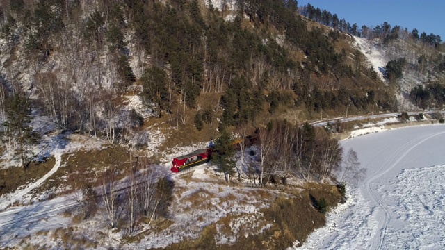 空中摄影:乘客乘坐客运列车，要经过高山和冰封的贝加尔湖视频素材