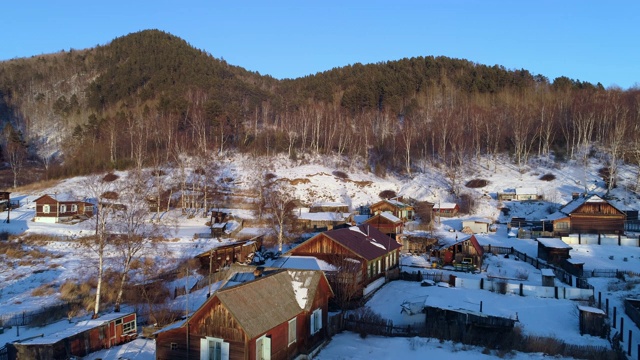 空中:无人机接近被积雪覆盖的山区的居民区——俄罗斯贝加尔湖视频素材