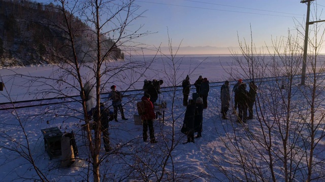 游客在贝加尔湖积雪覆盖的土地上乘坐铁路视频素材